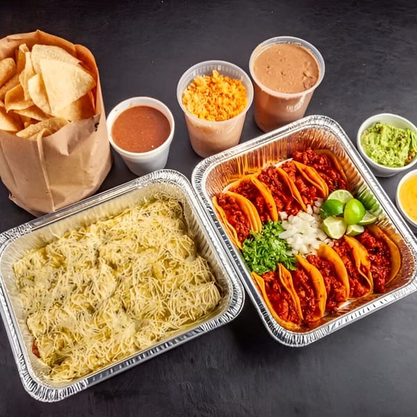 Dona Mary's Mexican feast with tacos, enchiladas, chips, salsa, guacamole, rice, and beans.